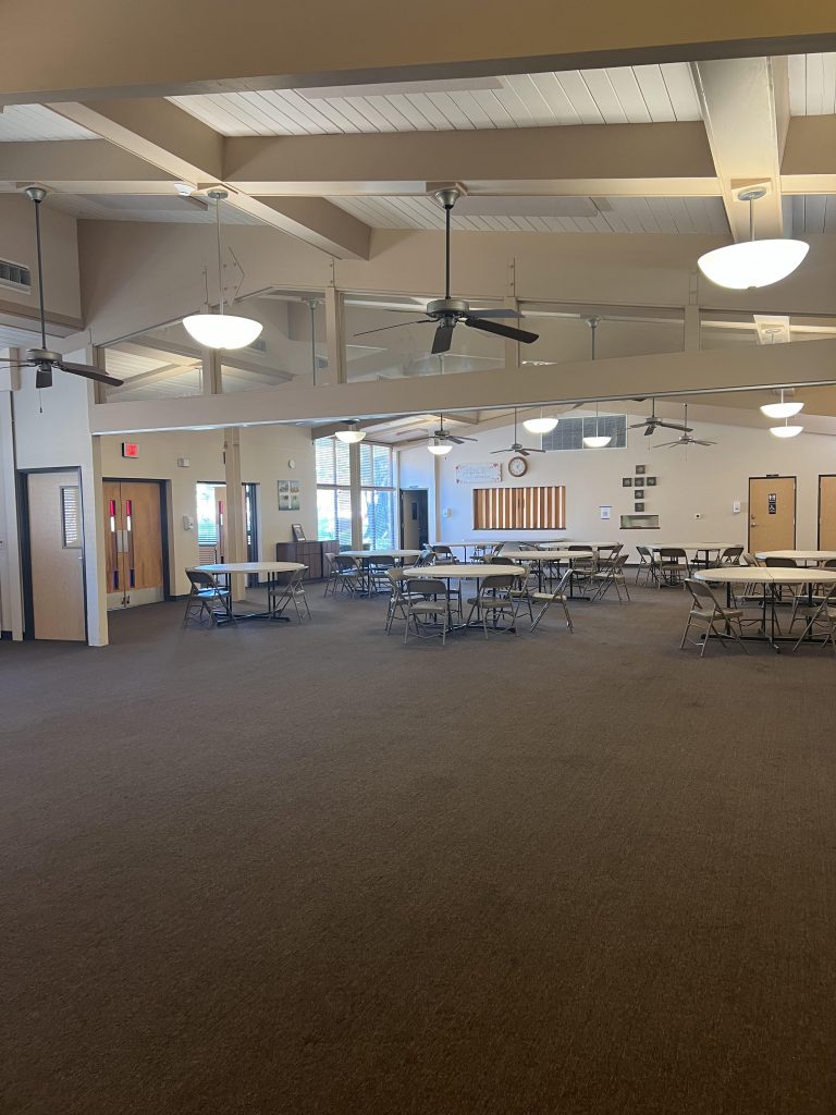 Photo of the Parish Hall. Tables and chairs are set up on the far side. 